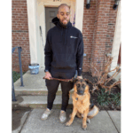 Quinn holding the leash of his guide dog on their front step