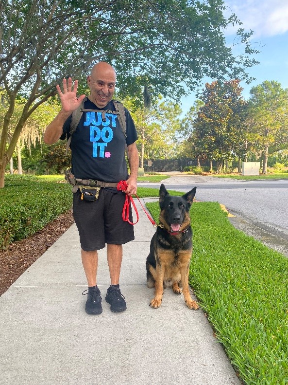 Yehia waves at the camera holding the leash of Vader