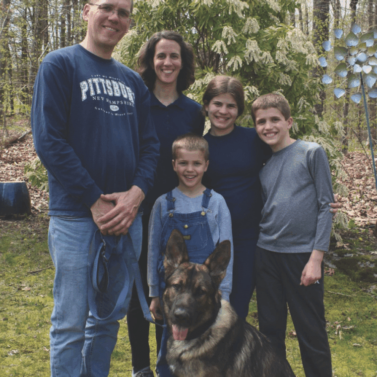 Group photo of the helming family standing together with "Ivan" sitting in front of them
